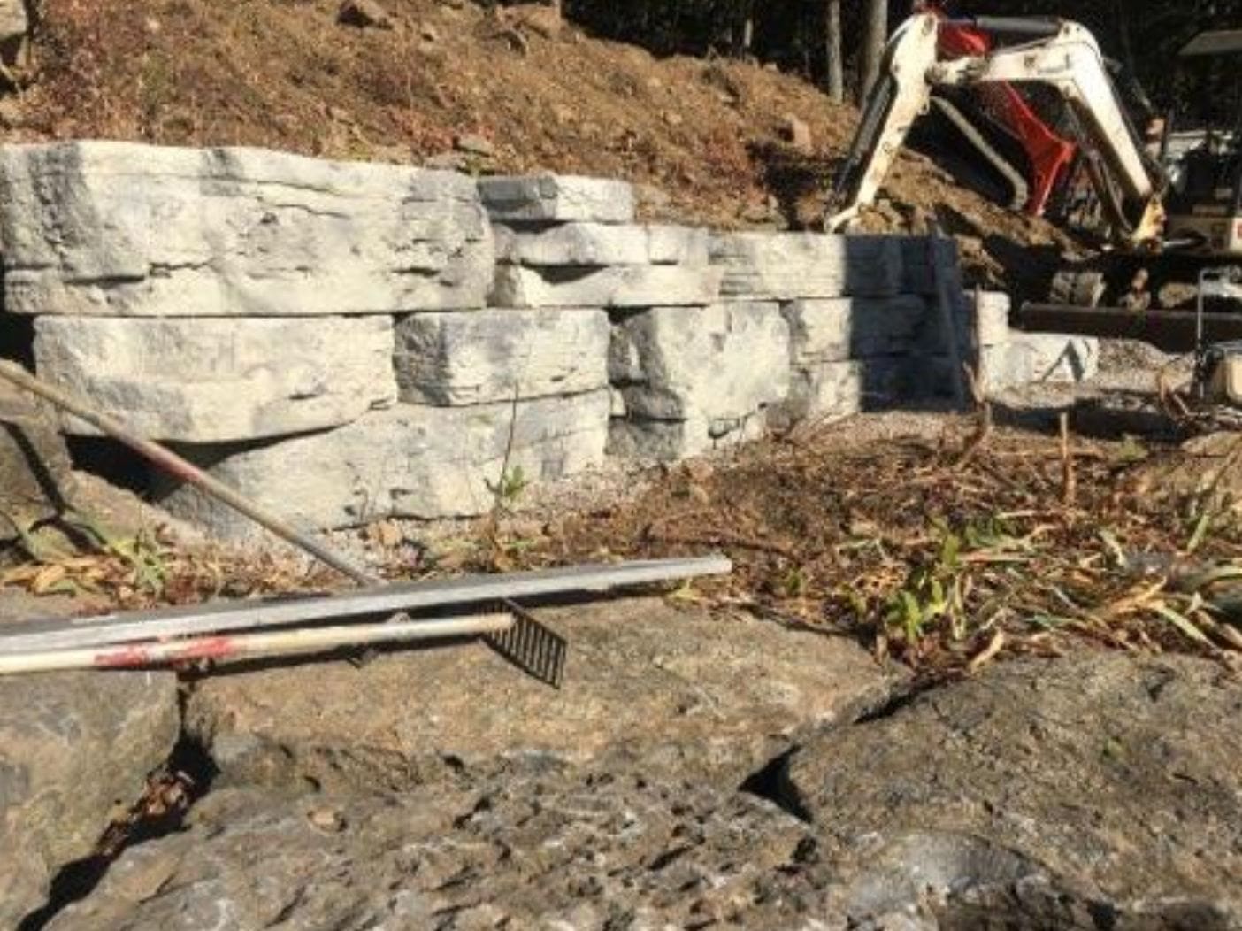 A construction site with a pile of rocks and a shovel.